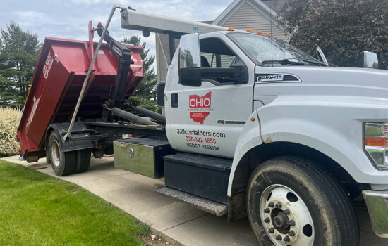 A truck dropping off a dumpster
