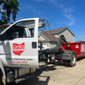 A truck dropping off a dumpster